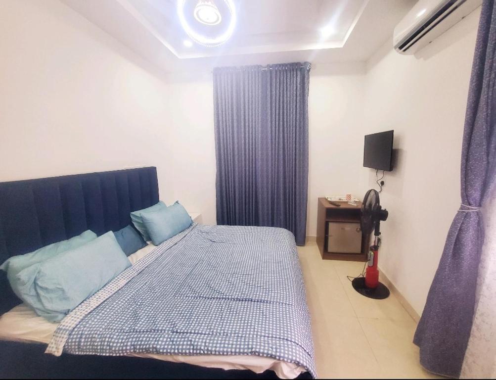 a bedroom with a large bed with blue pillows at 3 Bedroom Apartment in Lekki in Lekki