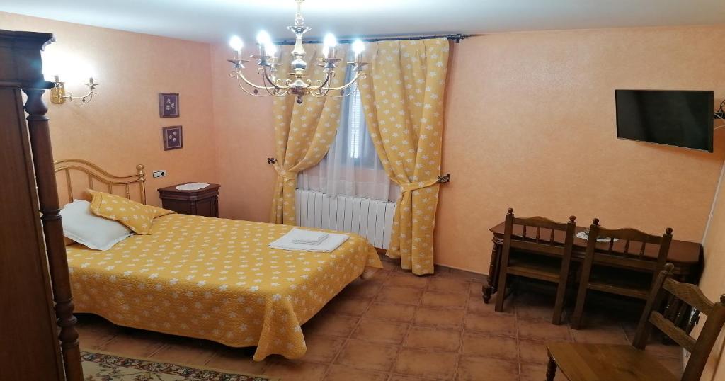 a bedroom with a bed and a chandelier at Villa y Corte - Castillo in Ampudia