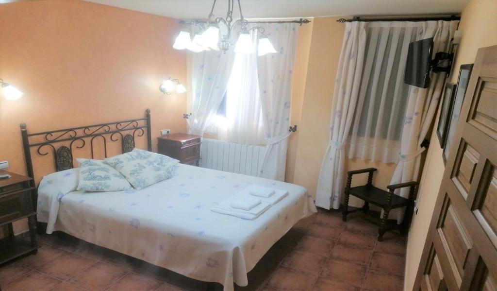 um quarto com uma cama branca e uma janela em Villa y Corte - Colegiata em Ampudia