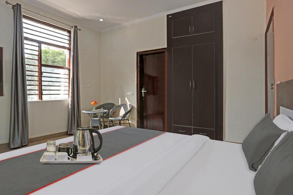グルガオンにあるOYO Rajvanshi Residencyのベッドルーム1室(ベッド1台、テーブル、椅子付)