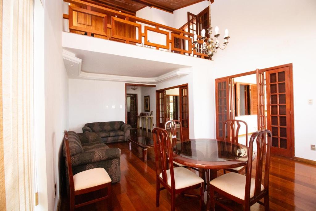 a dining room with a table and a couch at Chacara totalmente equipada em Juiz de Fora MG in Juiz de Fora