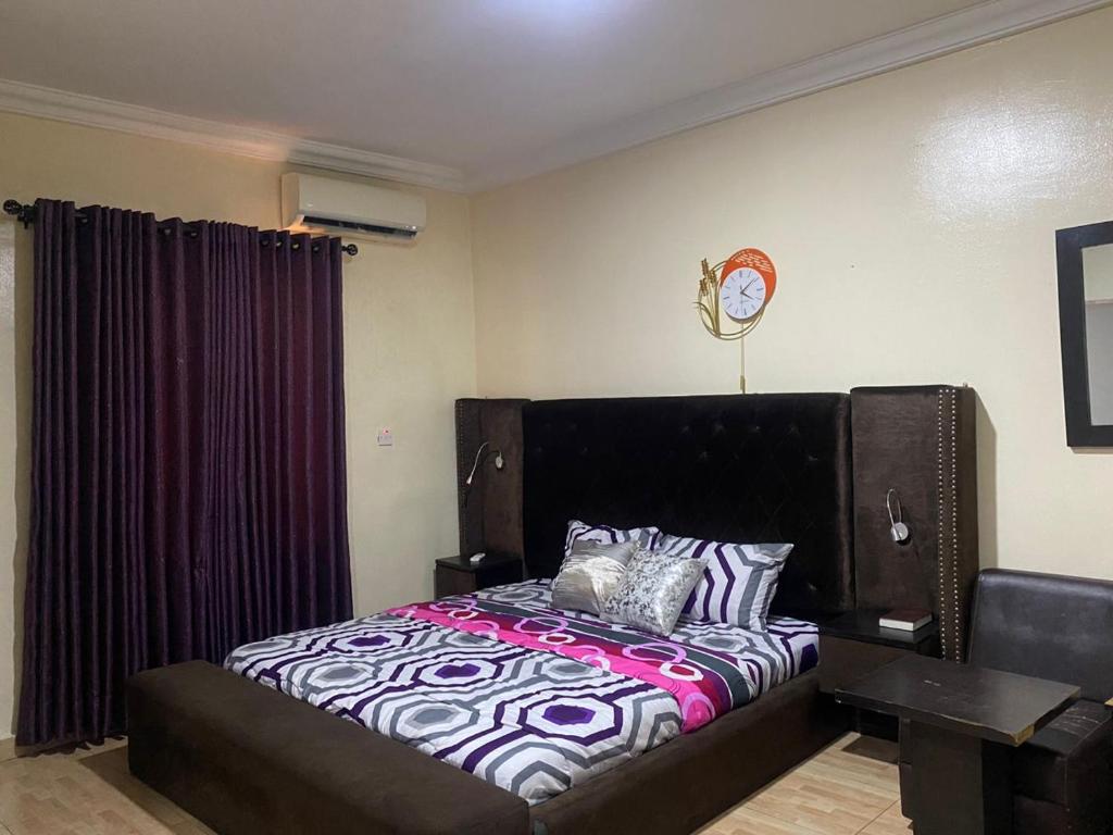 a bedroom with a large bed with a black headboard at Light house in Lagos