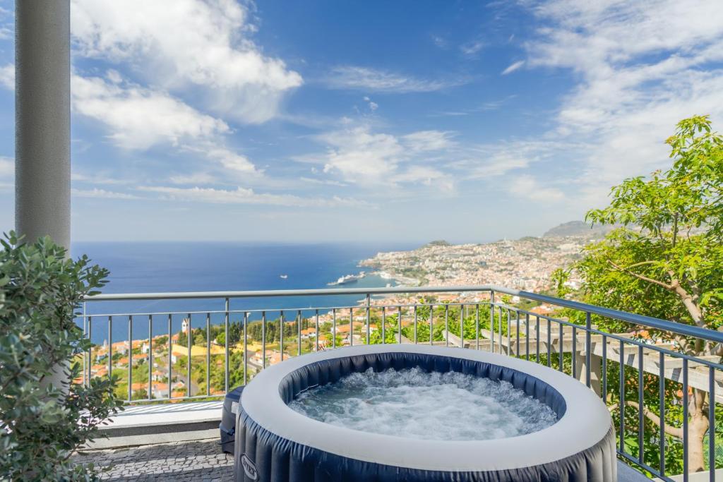 a hot tub on a balcony with a view of the ocean at Bay Bliss by Atlantic Holiday in Funchal
