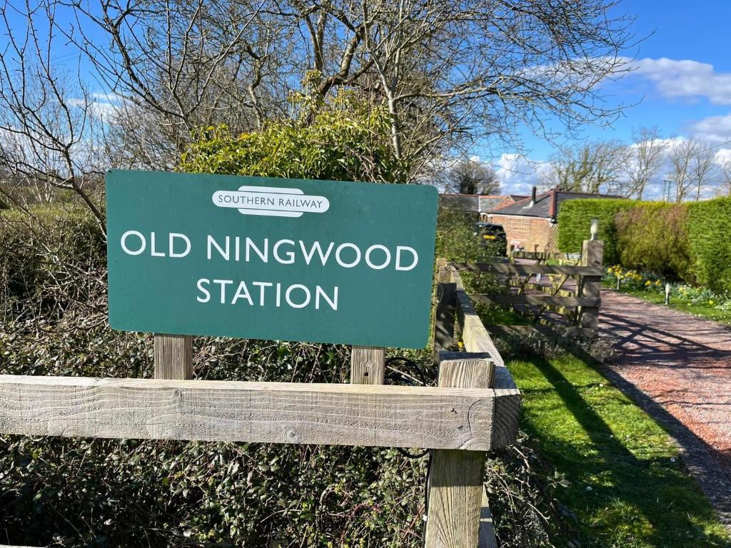una señal para la vieja estación de Kings en un jardín en Old Ningwood Station Bed & Breakfast, en Shalfleet