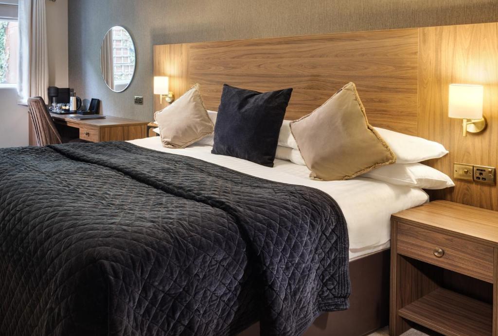 a bedroom with a large bed with pillows at The Seven Chester in Chester