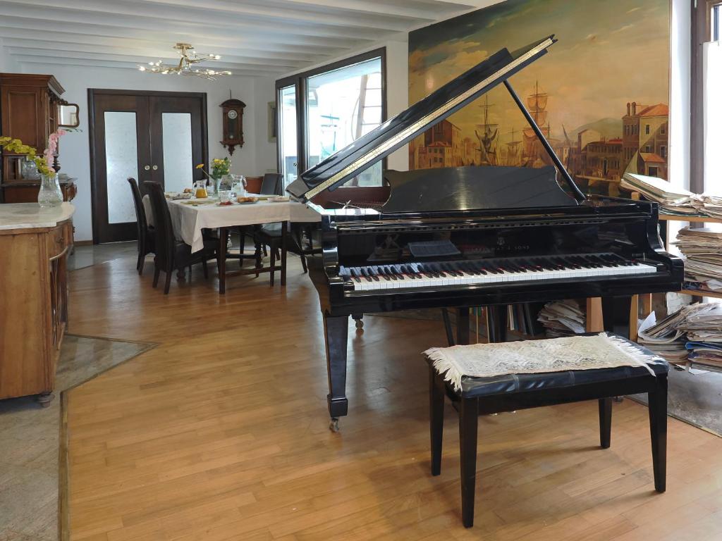 a piano in a room with a table and a dining room at B & B Da Lella in Trieste