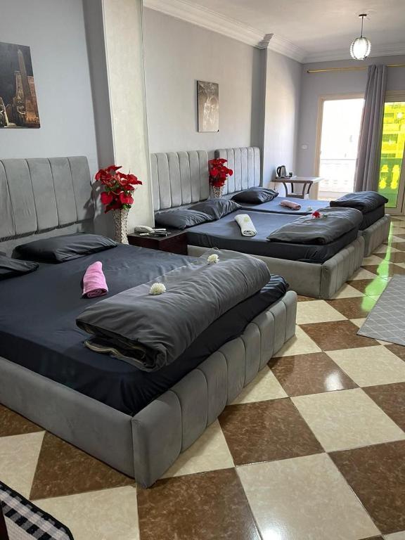 three beds are lined up in a room at Explore Stars Pyramids View in Cairo