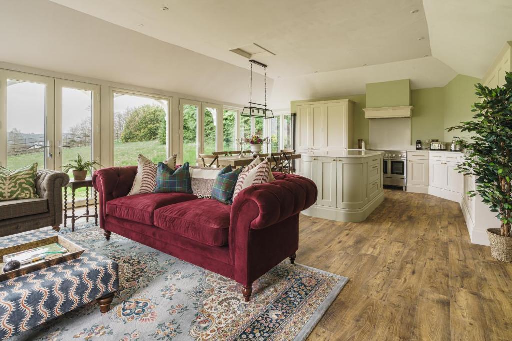 uma sala de estar com um sofá vermelho e uma cozinha em Mellguards, 4-Bed Country Cottage, in Howtown em Watermillock