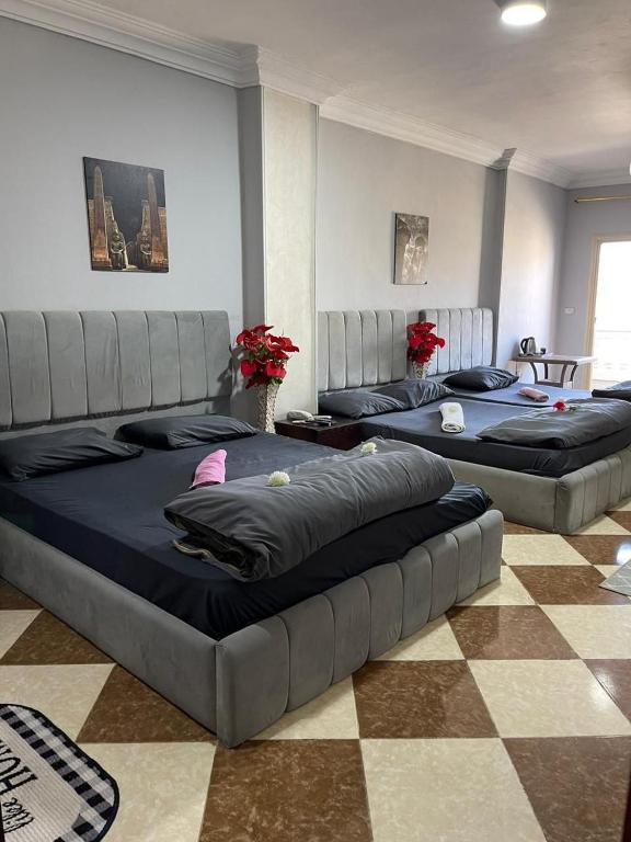 two large beds in a room with a checkered floor at Explore Stars Pyramids View in Cairo