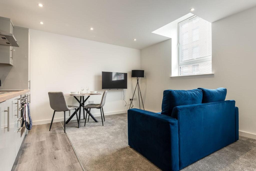a living room with a blue couch and a table at Contemporary Studio Apartment in Central Rotherham in Rotherham
