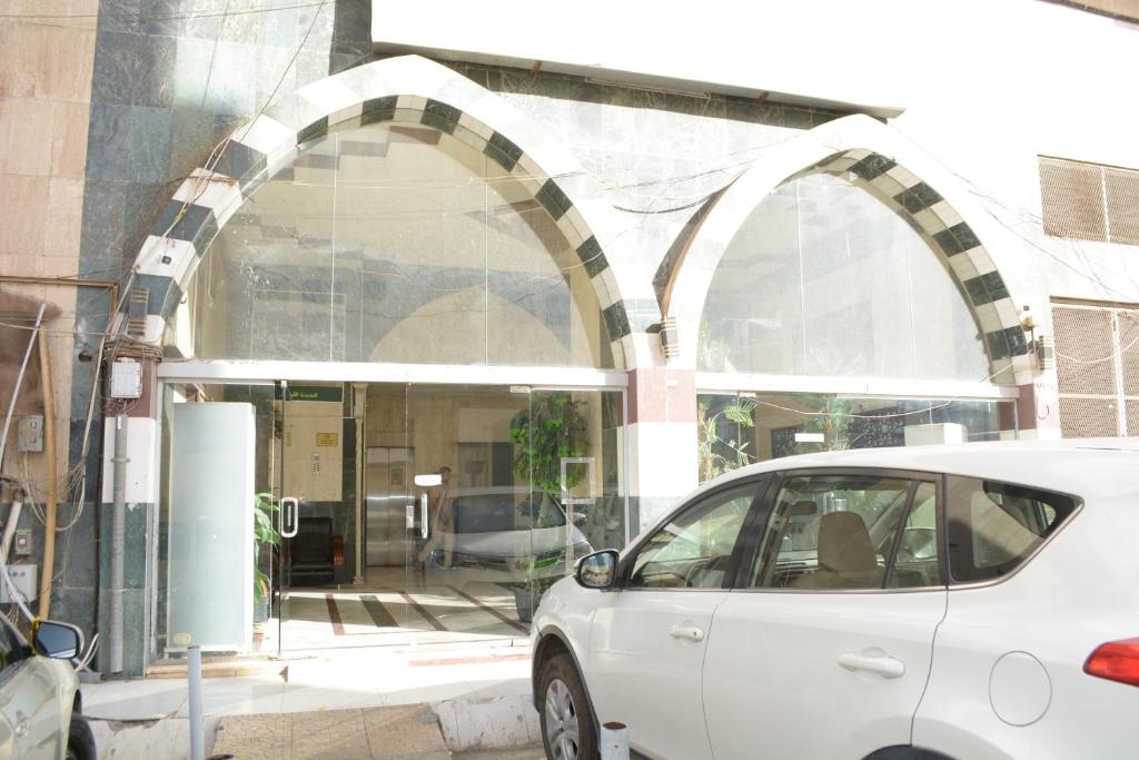ein weißes Auto, das vor einem Gebäude parkt in der Unterkunft الراقية للوحدات السكنية المفروشة in Medina