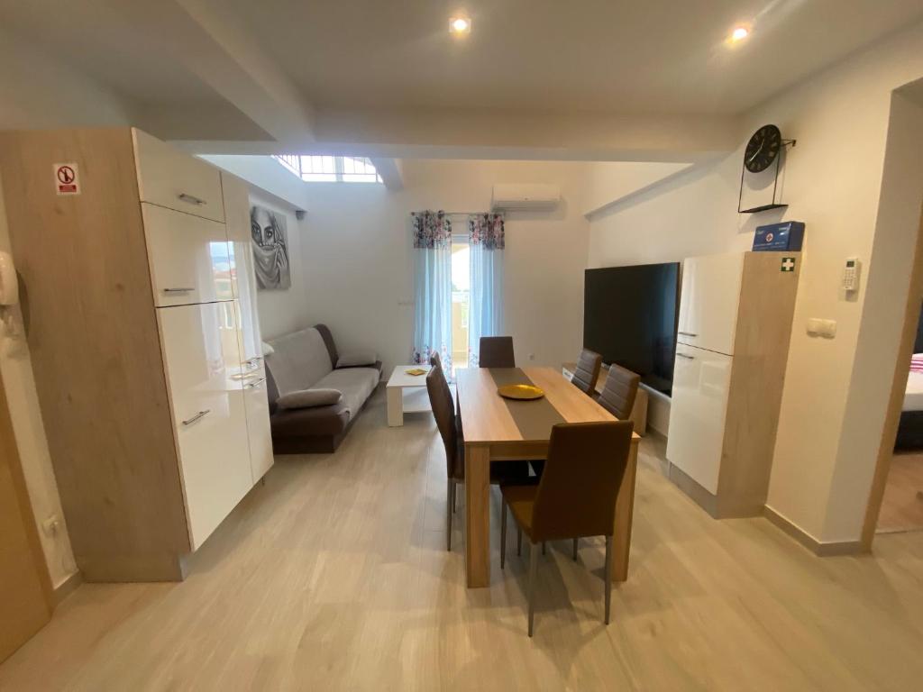 a kitchen and dining room with a table and a couch at Apartmani Spaija in Kaštela