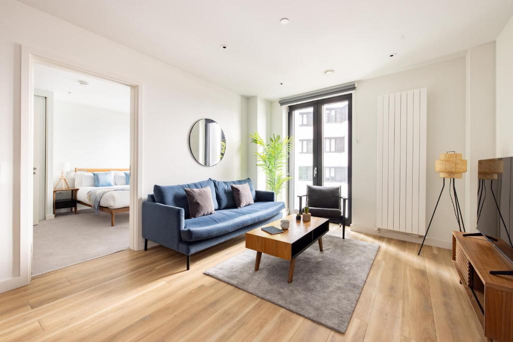 a living room with a blue couch and a table at London Croydon by Charles Hope in Croydon