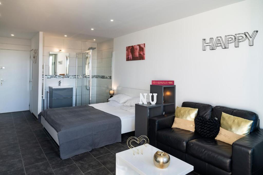 un salon avec un lit et un canapé dans l'établissement Studio Village Naturiste Héliopolis Exultation, au Cap d'Agde