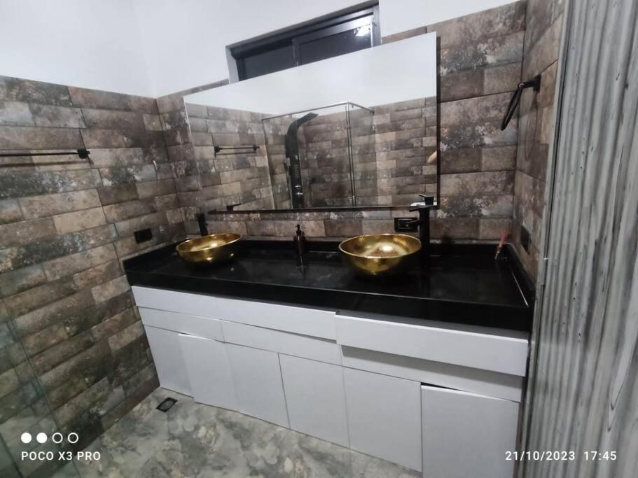 een badkamer met twee wastafels op een zwart aanrecht bij Casa Quinta Villa Cristal in Acacías