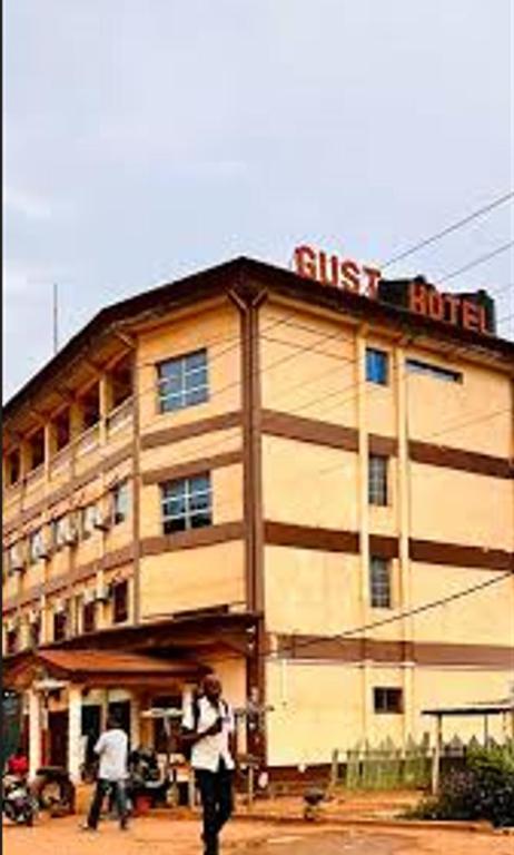 un homme debout devant un bâtiment dans l'établissement Gust Hotel, à Bangui