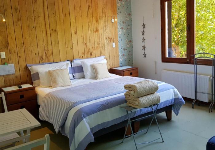 um quarto com uma cama com um cobertor azul e branco em Casapapudo Boutique Suites em Papudo