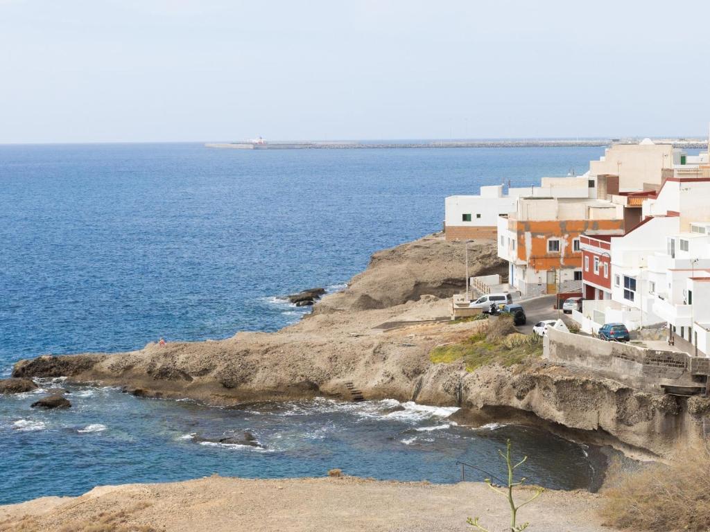 a group of white buildings on a cliff near the ocean at EK Brisa Del Mar Caleta Arico in Arico