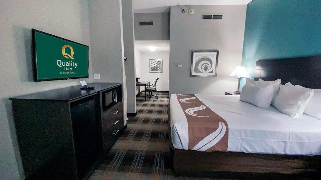 een hotelkamer met een bed en een flatscreen-tv bij Quality Inn Roseville-Detroit North in Roseville