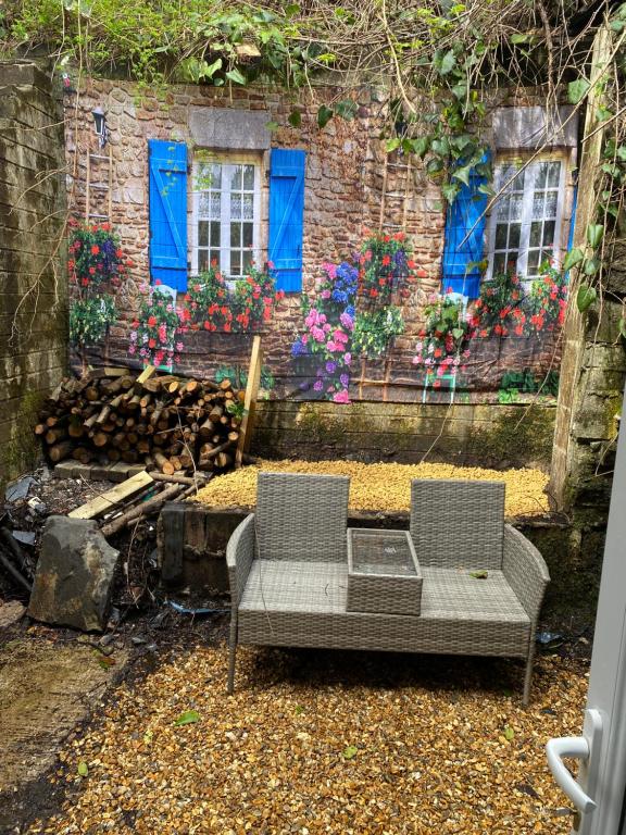 two chairs sitting in front of a building with blue windows at Mountain View in Llwyn-y-pia