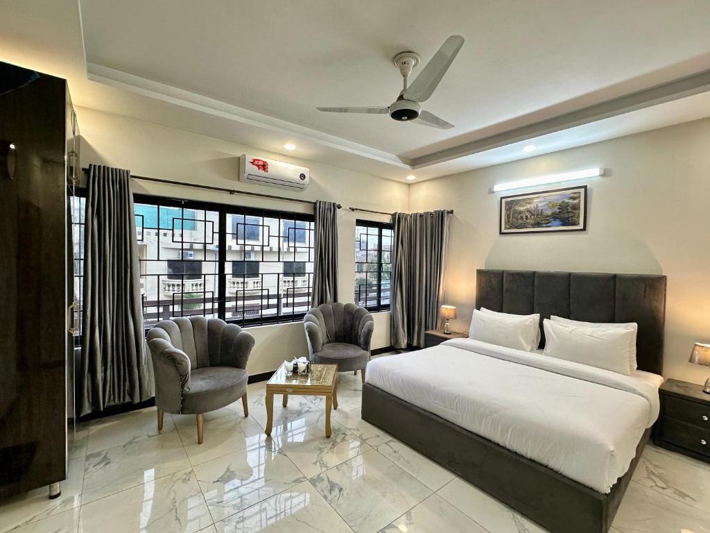 een hotelkamer met een bed en twee stoelen bij Dream Executive Guest House in Islamabad