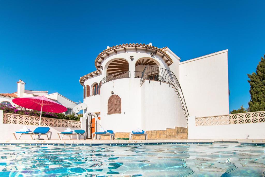 una piscina frente a un edificio blanco en Villa Rachelle by Abahana Villas, en Calpe