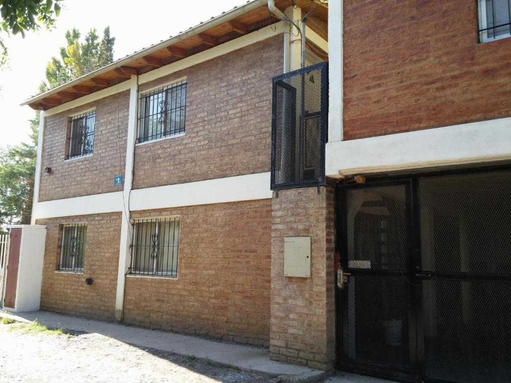 un edificio de ladrillo con la puerta abierta en una calle en Departamentos Nqn Equipados en Neuquén