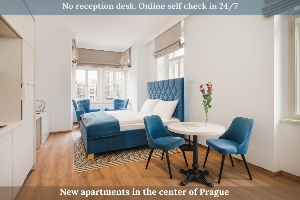 プラハにあるNOBILIS RESIDENCEのベッド、椅子、テーブルが備わる客室です。