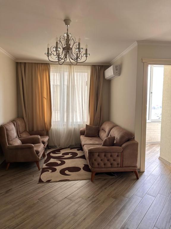 sala de estar con sofá, sillas y lámpara de araña en batumi apartament en Batumi