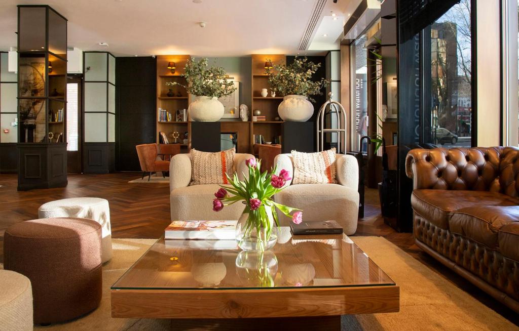 a living room with couches and a coffee table at H10 London Waterloo in London