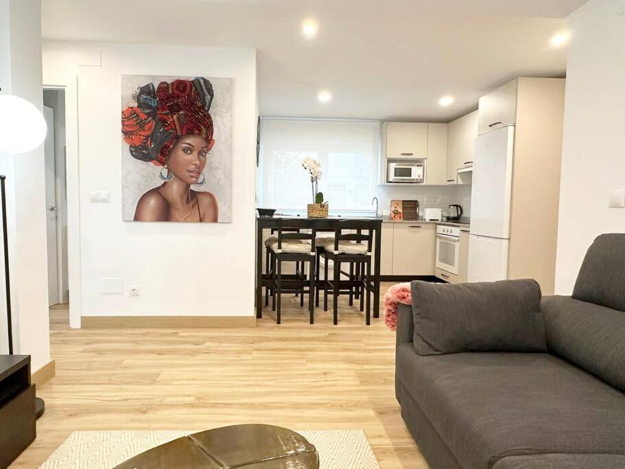 uma sala de estar com um sofá e uma cozinha com uma mesa em Apartamento reformado en Santoña em Santoña