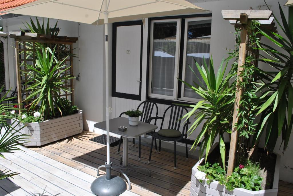 a patio with a table and chairs and plants at Hotel Ty Gwenn La Baule in La Baule