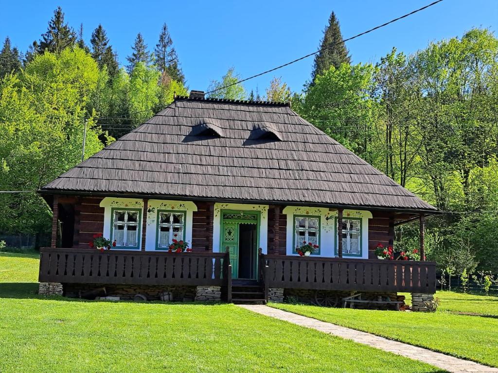 a small house with a porch on a lawn at Casa Felicia in Suceviţa