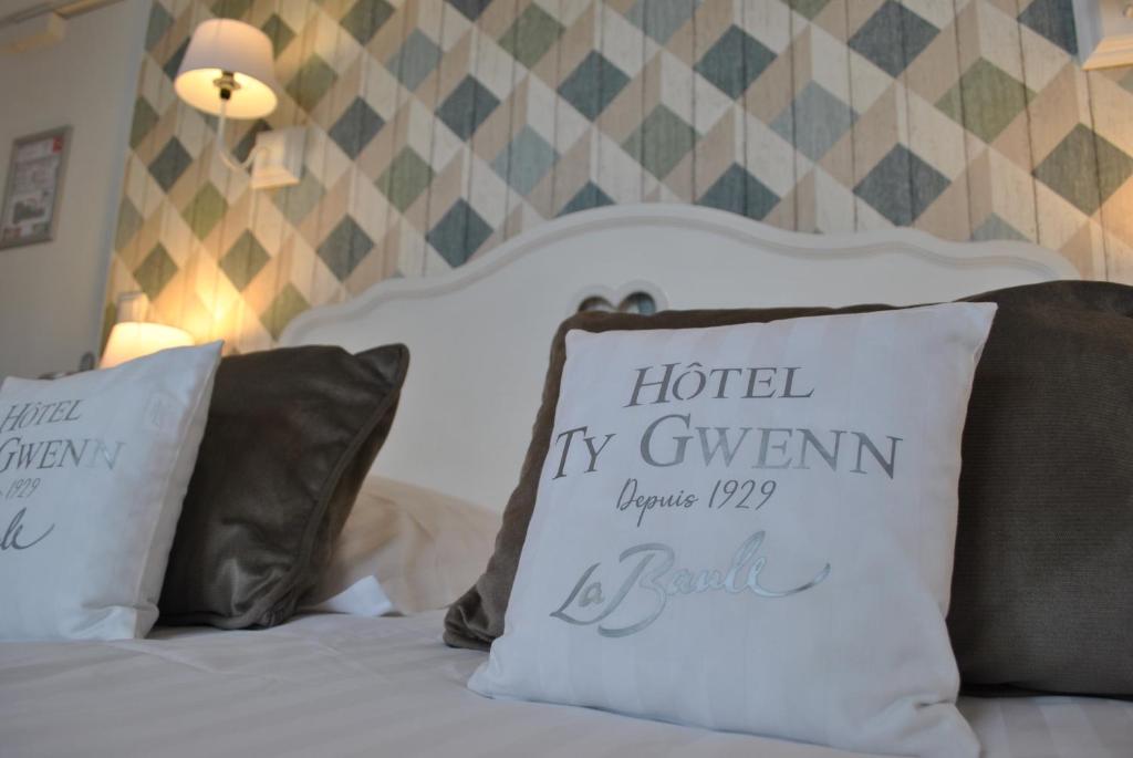 a bed with two pillows on top of it at Hotel Ty Gwenn La Baule in La Baule