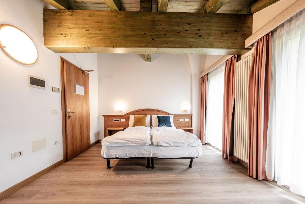 コンメッツァドゥーラにあるHotel La Noria Alpine B&Bの木製の天井のベッドルーム1室(ベッド1台付)