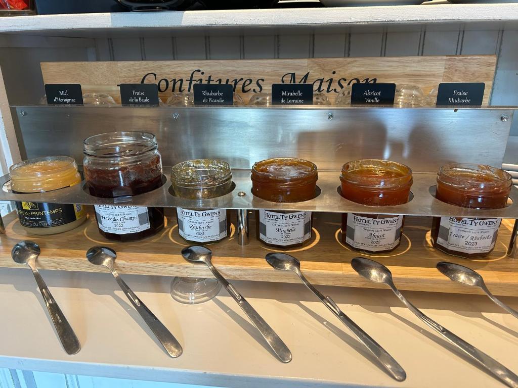 a display of jars of honey and spoons on a shelf at Hotel Ty Gwenn La Baule in La Baule
