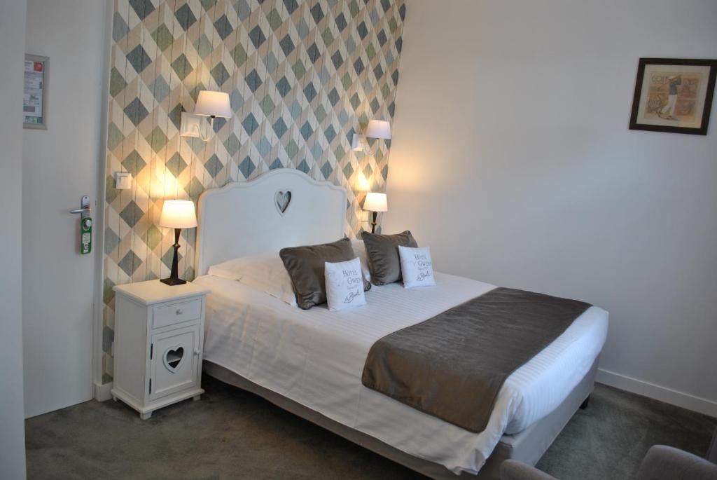 a bedroom with a bed with two lamps on it at Hotel Ty Gwenn La Baule in La Baule