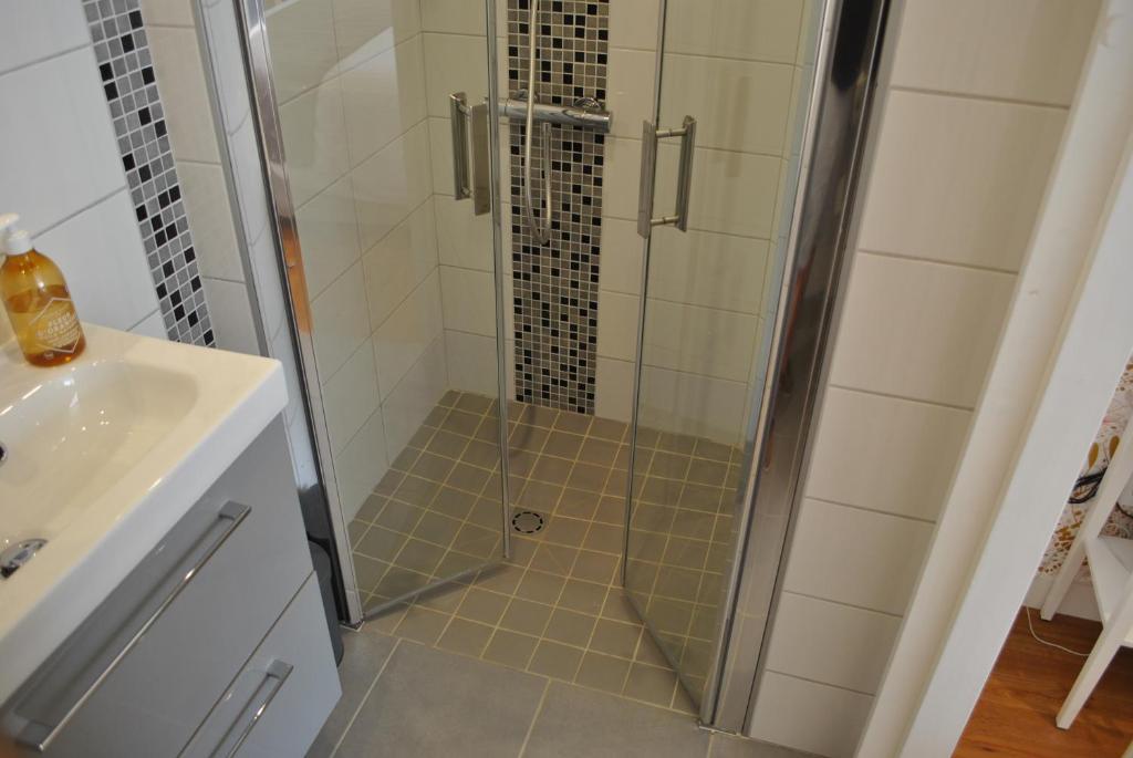 a shower with a glass door in a bathroom at Hotel Ty Gwenn La Baule in La Baule