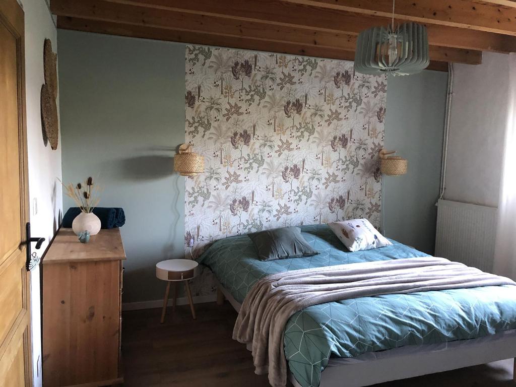 a bedroom with a bed with a floral wall at La Bastilac chambre Nature in Garganvillar