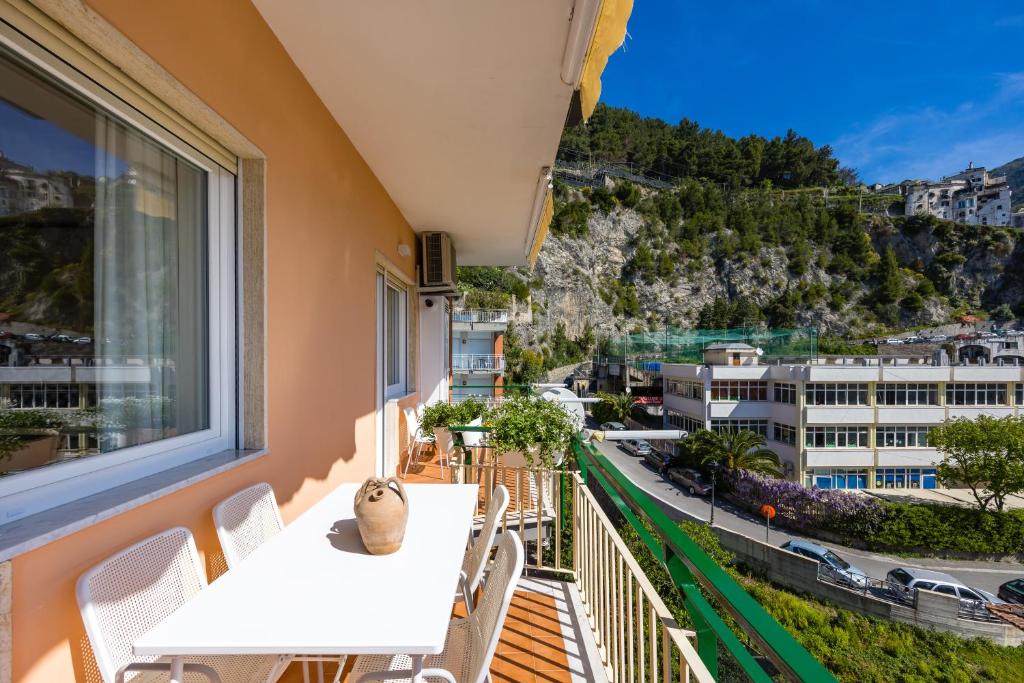 a balcony with tables and chairs and a view of a city at Residence Panoramic in Maiori