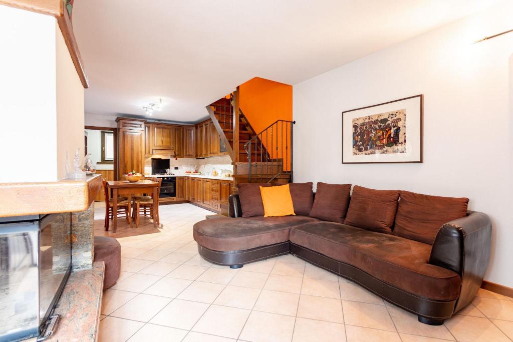 Il comprend un salon avec un canapé brun et une cuisine. dans l'établissement Gelsomino Stone House, à Stazzona
