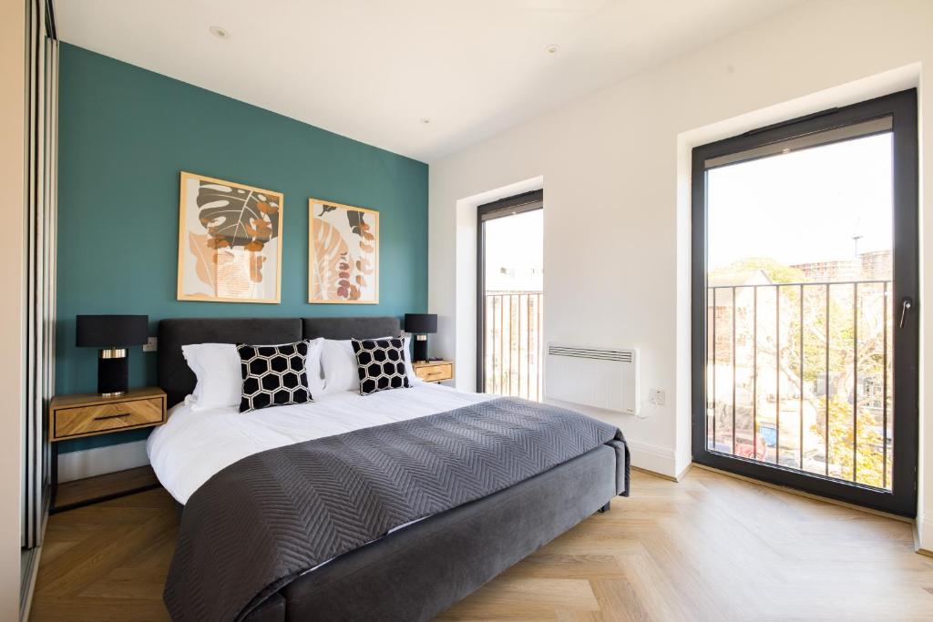 sypialnia z dużym łóżkiem z niebieską ścianą w obiekcie Staines Riverside by Charles Hope w mieście Staines