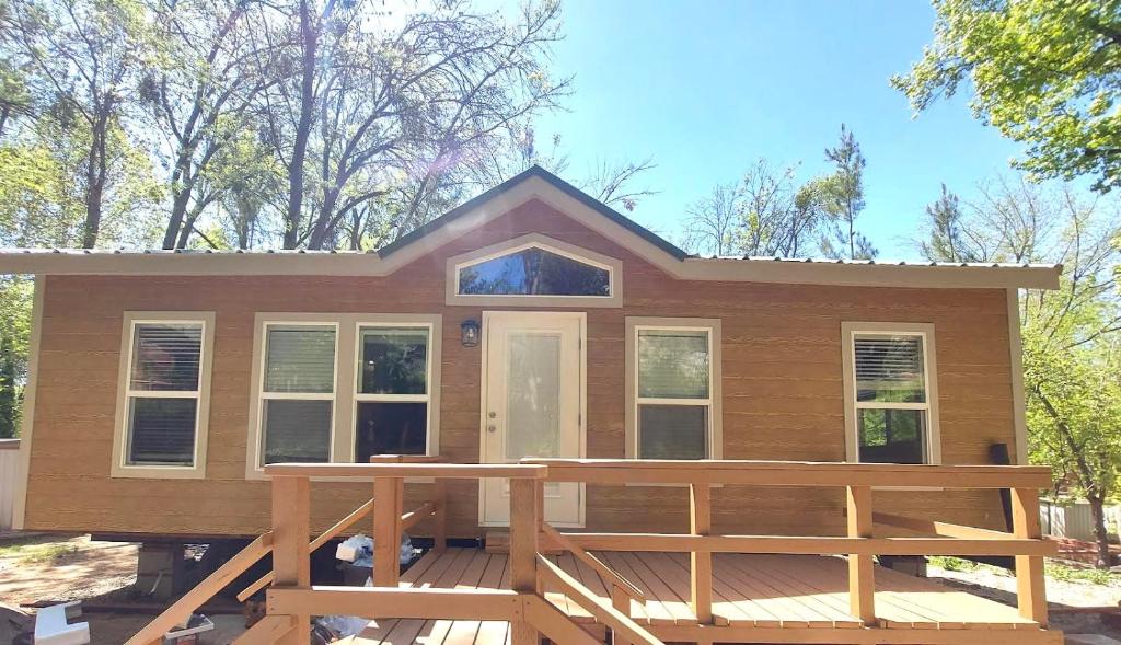 a tiny house with a deck in front of it at Brandnew cabin in Kernville