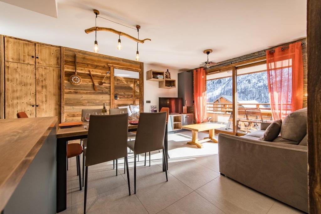 a kitchen and living room with a table and a couch at Bel appartement 6 personnes avec deux terrasses ensoleillées au coeur du village in Saint-Sorlin-dʼArves