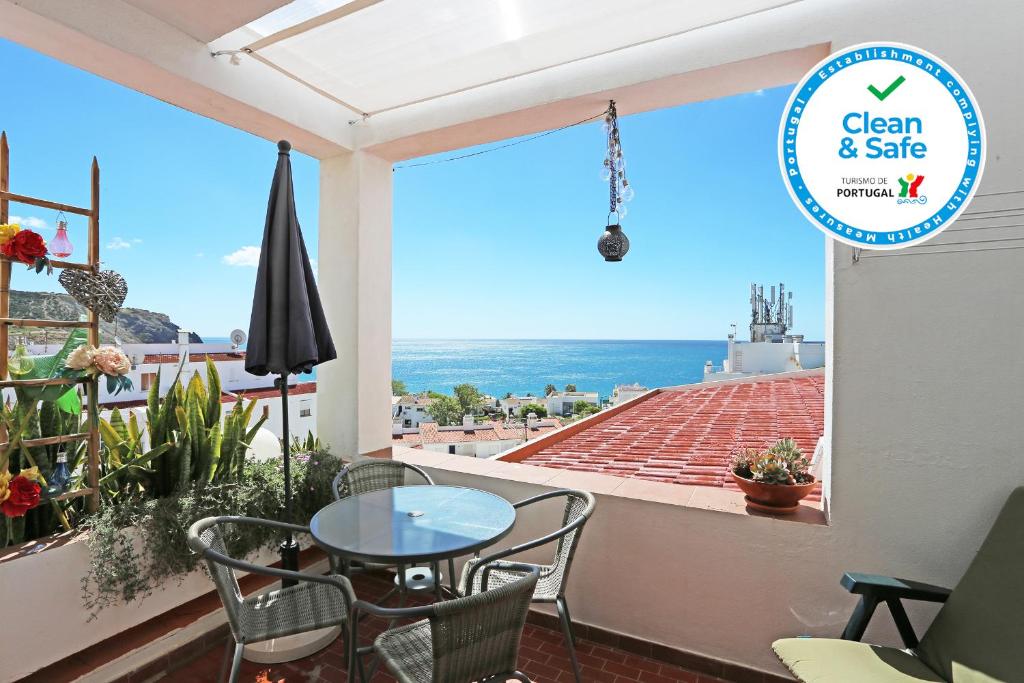 ein Balkon mit Tisch und Stühlen und Blick auf das Meer in der Unterkunft Casa Le Ferreira in Praia da Luz in Luz
