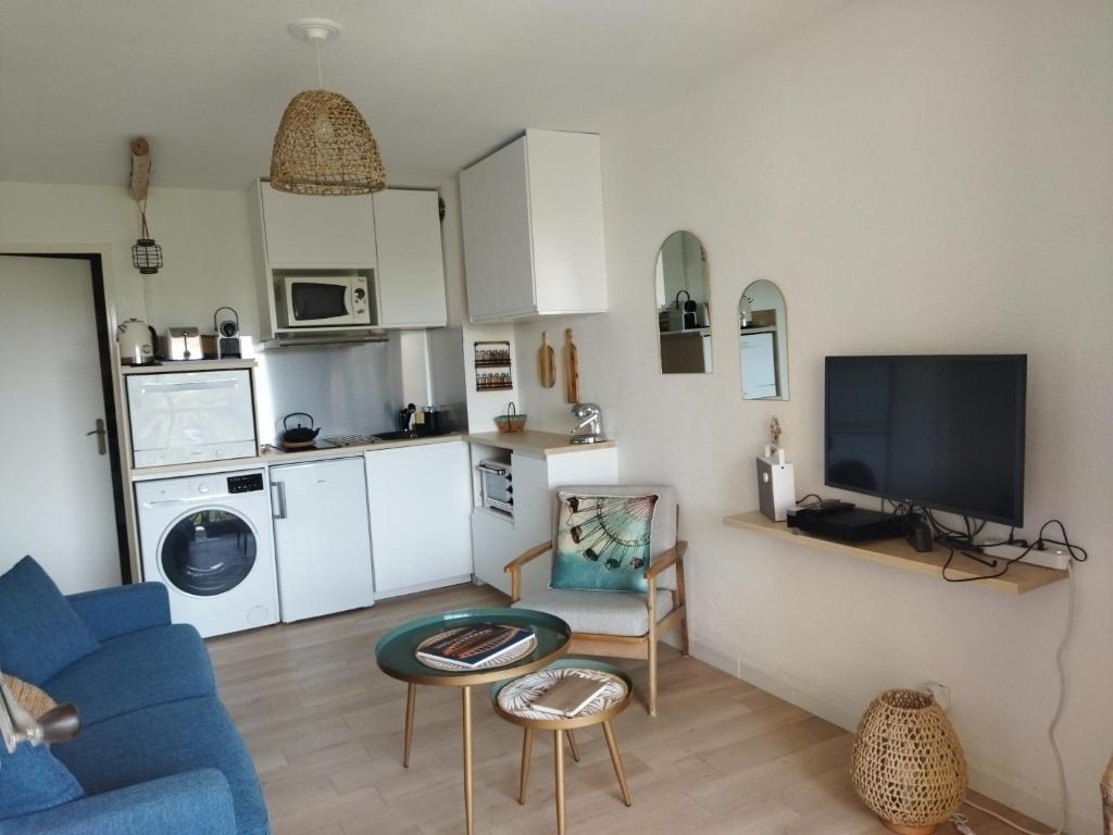 un salon avec un canapé bleu et une cuisine dans l'établissement Santa Maxima, à Sainte-Maxime