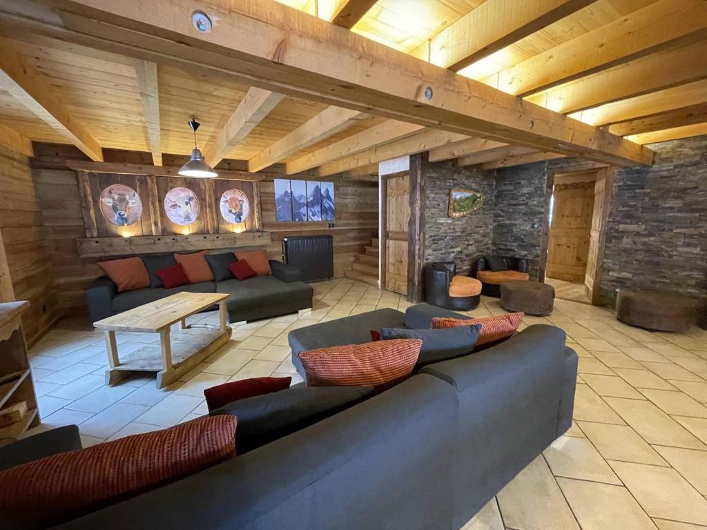 a living room with a couch and a table at Chalet montagnard 15 personnes - proche du centre du village in Saint-Sorlin-dʼArves