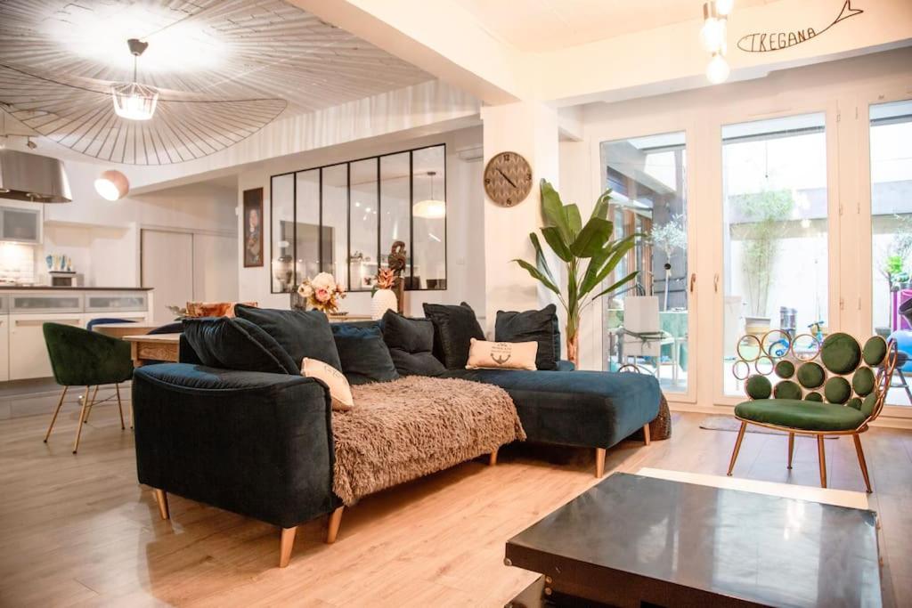 ein Wohnzimmer mit einem blauen Sofa und einem Tisch in der Unterkunft Appartment loft style - Stade de France in Saint-Denis