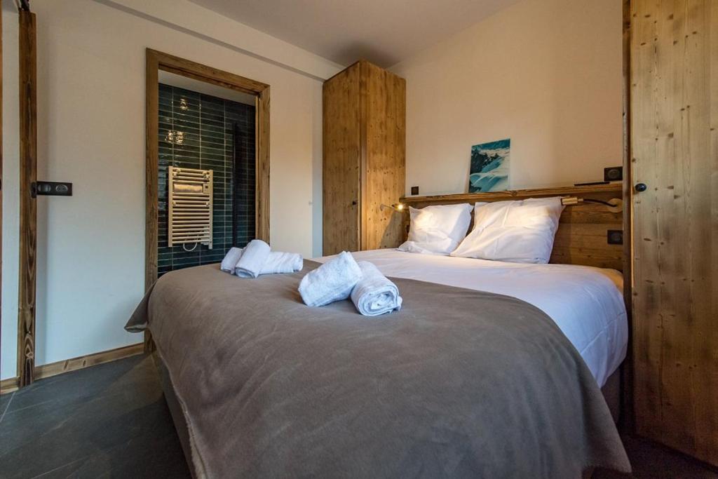 a bedroom with two beds with towels on them at Appartement neuf avec une grande terrasse au cœur du village - 6 personnes in Saint-Sorlin-dʼArves