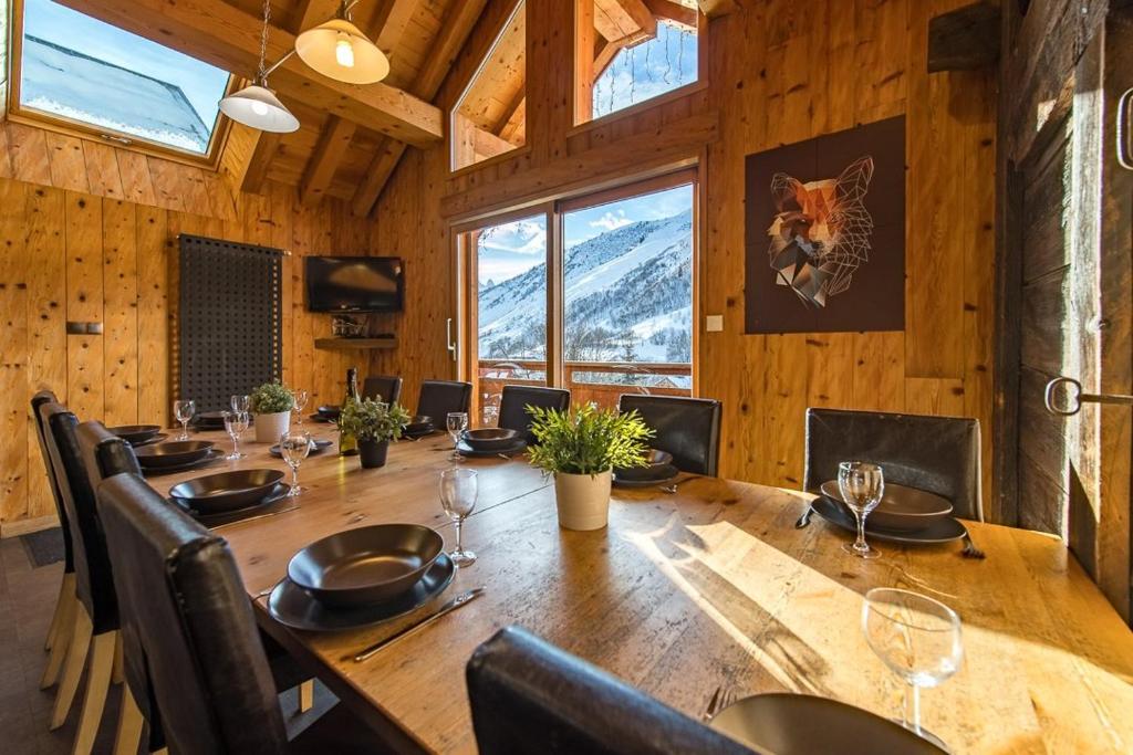a dining room with a large wooden table and chairs at Chalet de charme 11 personnes proche du centre du village in Saint-Sorlin-dʼArves
